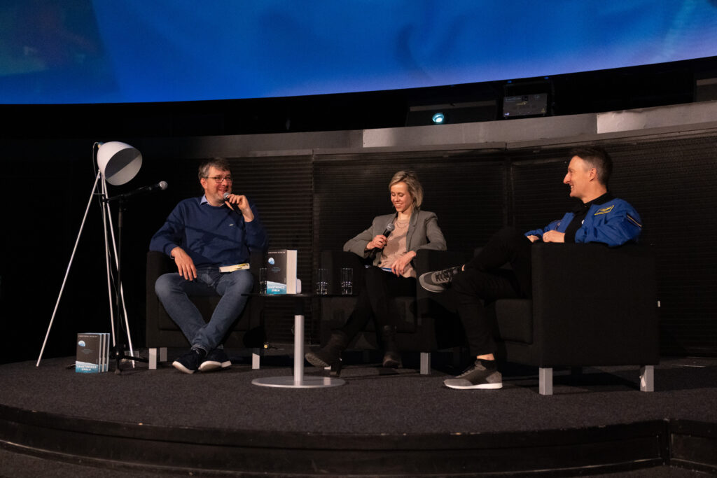 Moderation Kristin Linde, Lesung mit ESA-Astronaut Matthias Maurer und SPIEGEL-Wissenschaftsautor Christoph Seidler, März 2025, Zeiss-Großplanetarium Berlin, © Mark Reichert